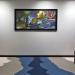 framed artwork hanging on wall between two chairs