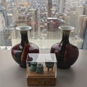 Two large ornamental vases in front of a large glass window